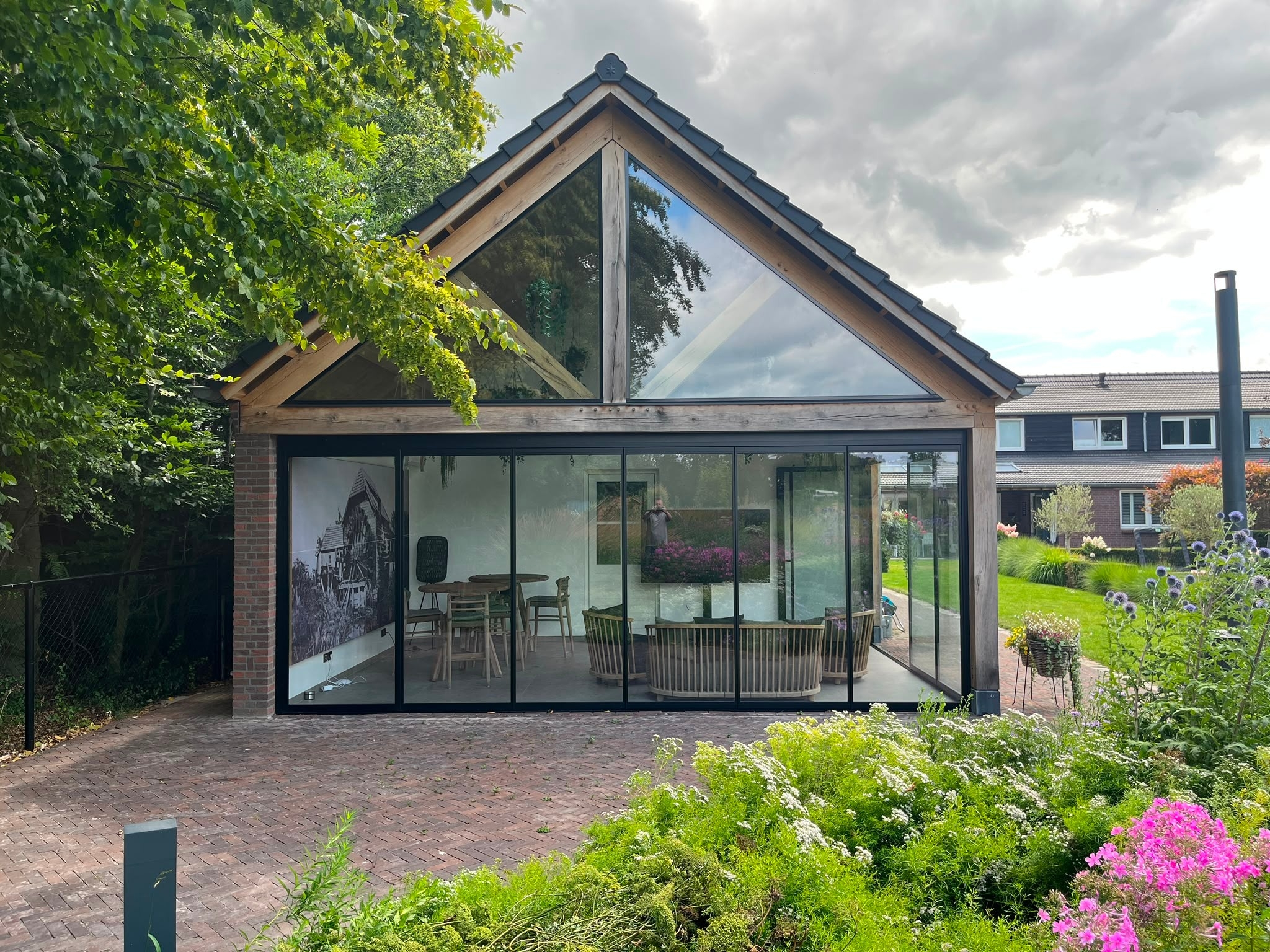 Black aluminum bifold glass doors fully opened connecting indoor living space to outdoor patio area